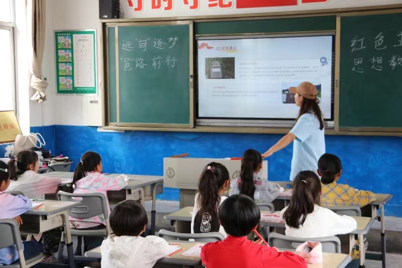 图为志愿者为孩子们进行红色主题创作.png