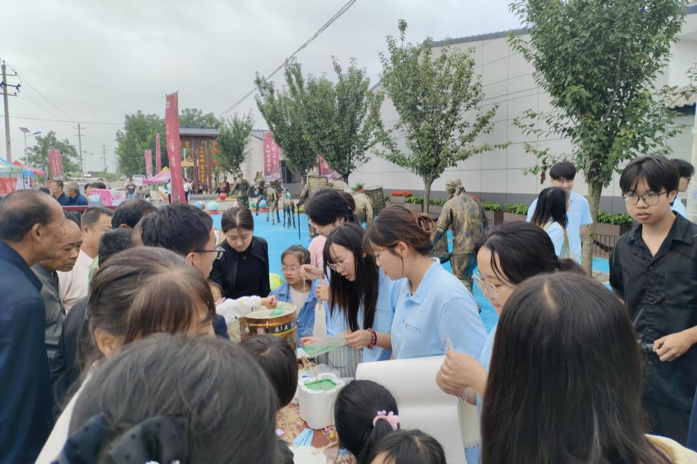 图为志愿者们组织当地村民、游客体验传统非遗漆扇的制作.png